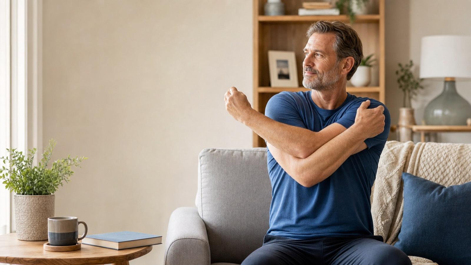 Man performing a gentle shoulder stretch during a home wellness routine